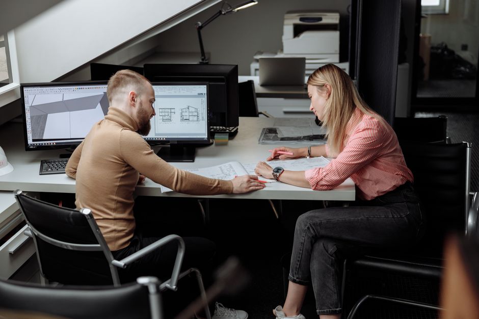 Two people discussing plans in a contemporary office