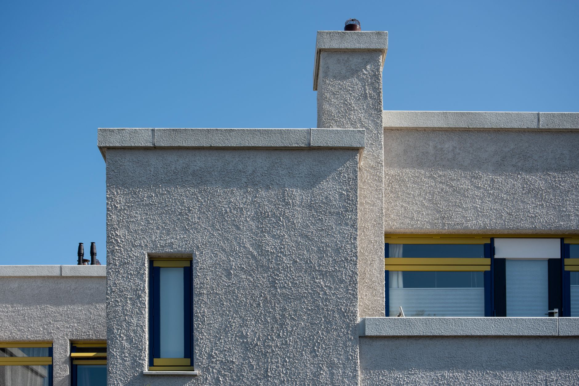 A modern concrete facade against a blue sky, Pulse Architecture